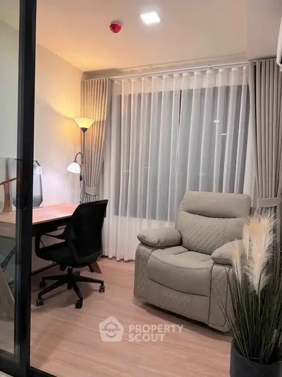 Cozy study room with modern desk, ergonomic chair, and plush recliner in a well-lit corner.