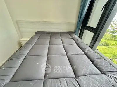 Cozy bedroom with large window offering scenic views, featuring a comfortable bed and modern decor.