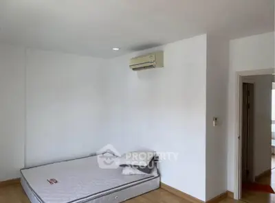 Spacious bedroom with minimalist design and air conditioning unit, perfect for comfort and relaxation.
