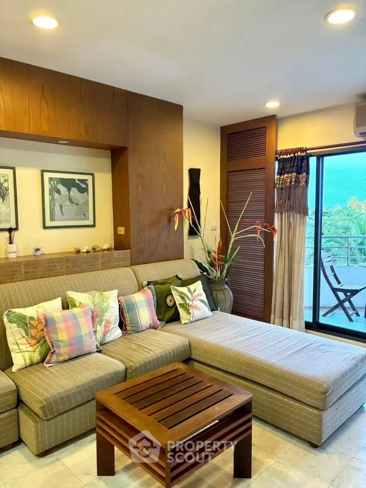 Stylish living room with cozy sectional sofa and balcony view, perfect for relaxation.