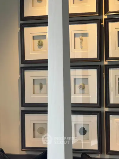 Elegant interior wall art display in modern living space with framed abstract pieces.