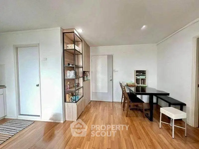 Spacious living room with wooden flooring and modern furniture in a cozy apartment.