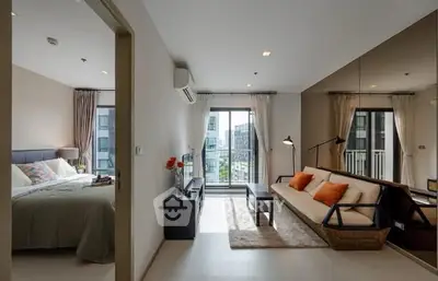 Modern apartment with open living room and bedroom, featuring a balcony view.