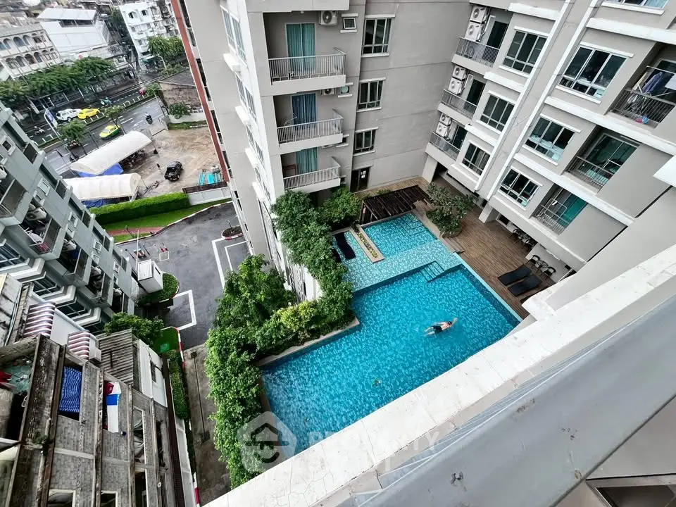 Stunning aerial view of modern apartment complex with inviting swimming pool and lush greenery.