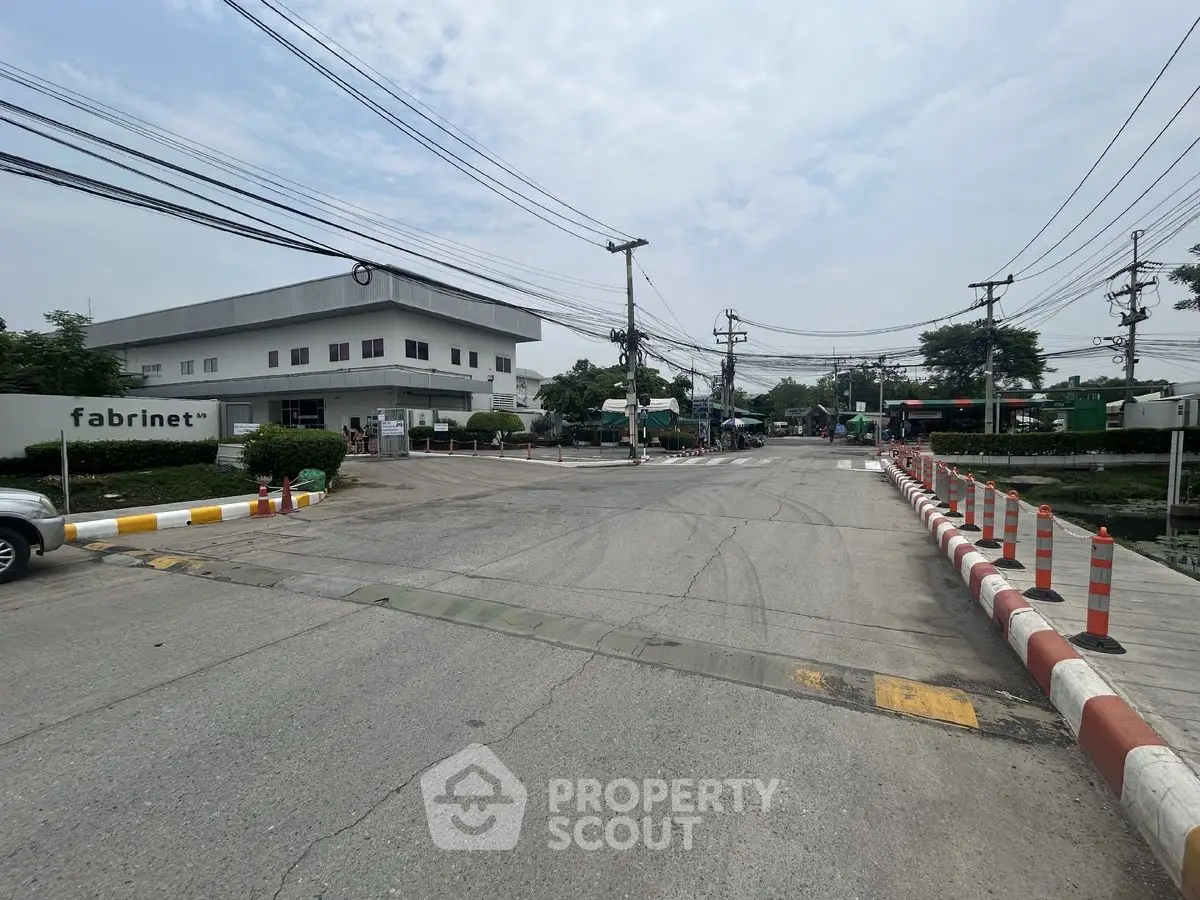 Industrial complex entrance with security barriers and signage