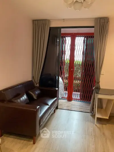 Cozy living room with leather sofa and balcony access