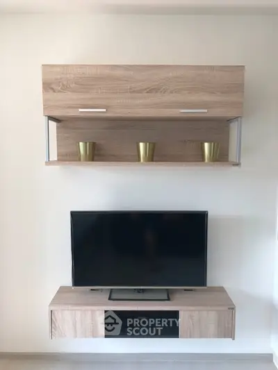 Modern living room with sleek wooden TV stand and wall-mounted shelf, perfect for stylish home entertainment setup.