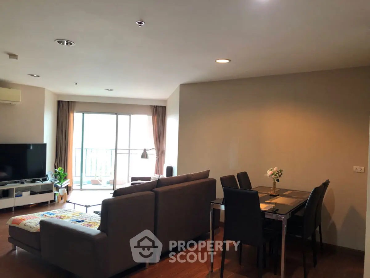 Spacious living room with modern furniture and balcony view in a stylish apartment.