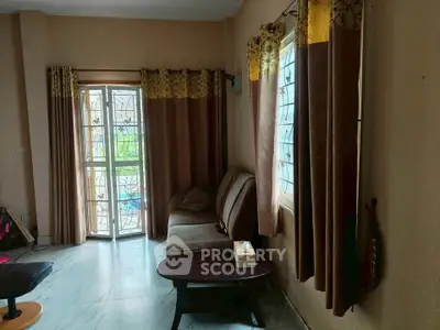 Cozy living room with elegant curtains and comfortable seating, perfect for relaxation.