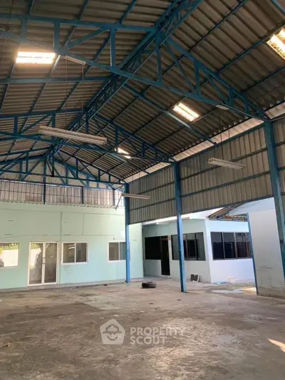 Spacious industrial warehouse with high ceilings and ample natural light.