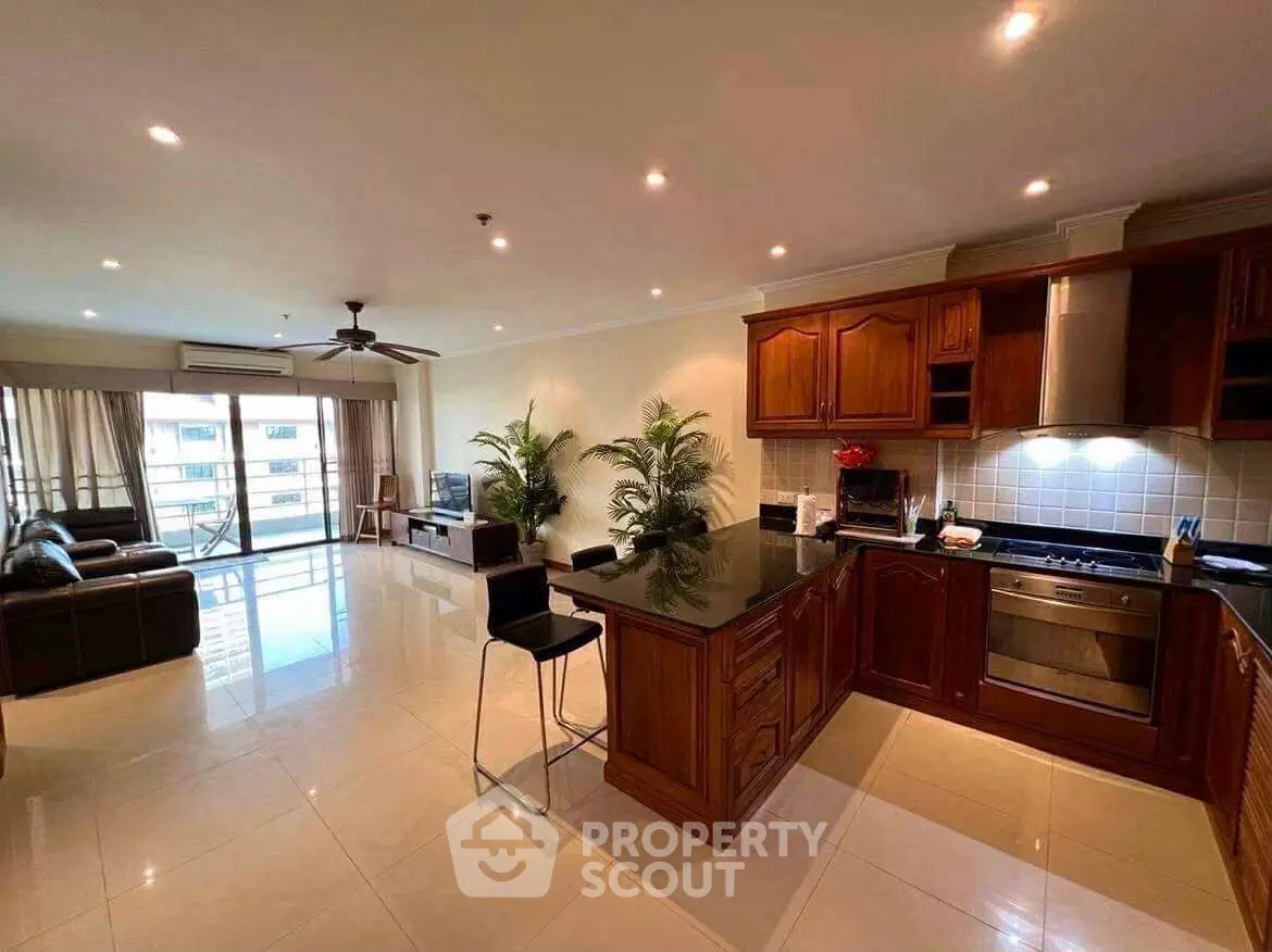 Spacious open-plan living room and kitchen with modern appliances and balcony view.