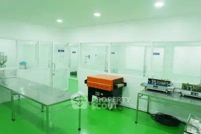 Modern industrial kitchen with stainless steel tables and green flooring