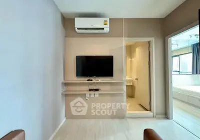 Modern living room with wall-mounted TV and air conditioning, leading to a bright bedroom.