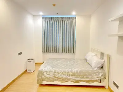 Spacious bedroom with cozy bed and elegant curtains in modern apartment.