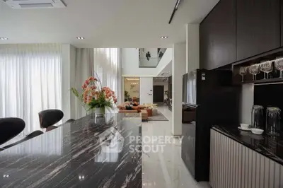 Luxurious open-plan kitchen and living area with modern decor and high ceilings.
