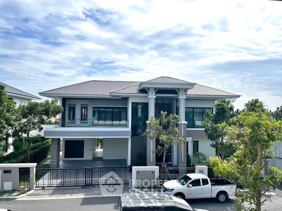 Stunning modern two-story house with spacious driveway and lush greenery, perfect for luxurious living.