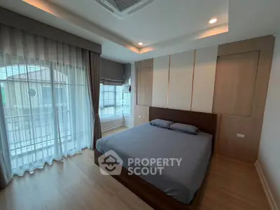 Modern bedroom with large windows and stylish decor in a contemporary home.