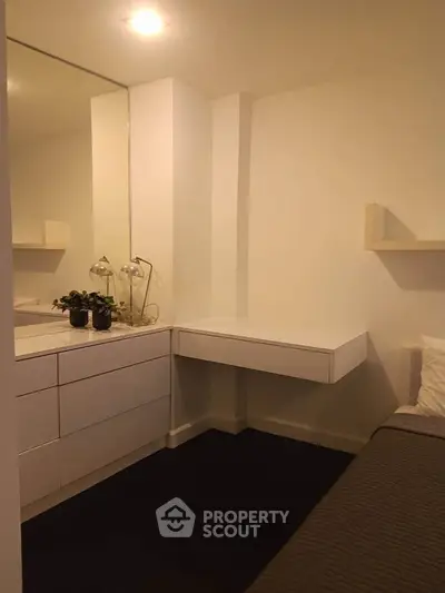 Cozy bedroom with modern minimalist design and built-in storage solutions.