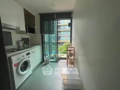 Modern kitchen with washing machine and balcony view in urban apartment
