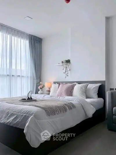 Modern bedroom with elegant decor and large window for natural light.