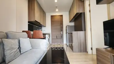 Modern apartment interior with sleek kitchen and cozy living area, featuring contemporary furniture and appliances.