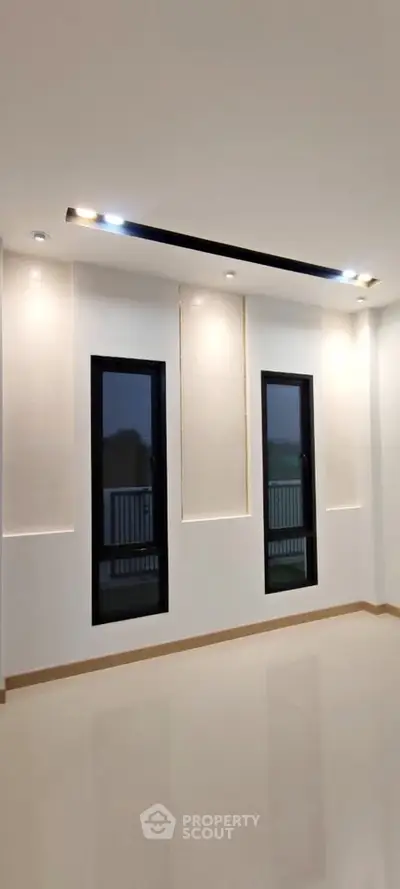 Modern minimalist living room with sleek lighting and large windows