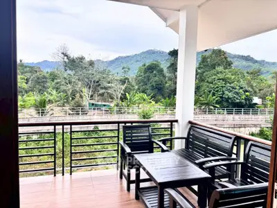 Stunning balcony view with lush greenery and mountain backdrop, perfect for relaxation and enjoying nature.