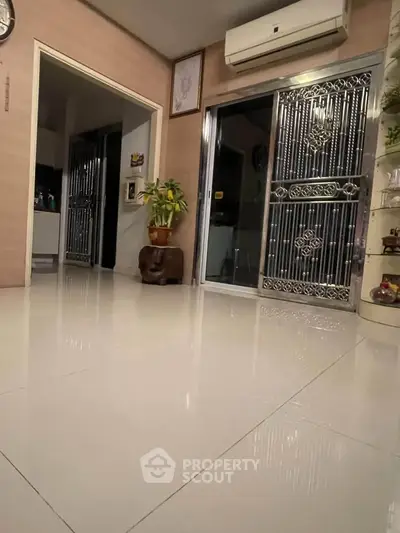 Spacious living area with sleek flooring and modern air conditioning unit.