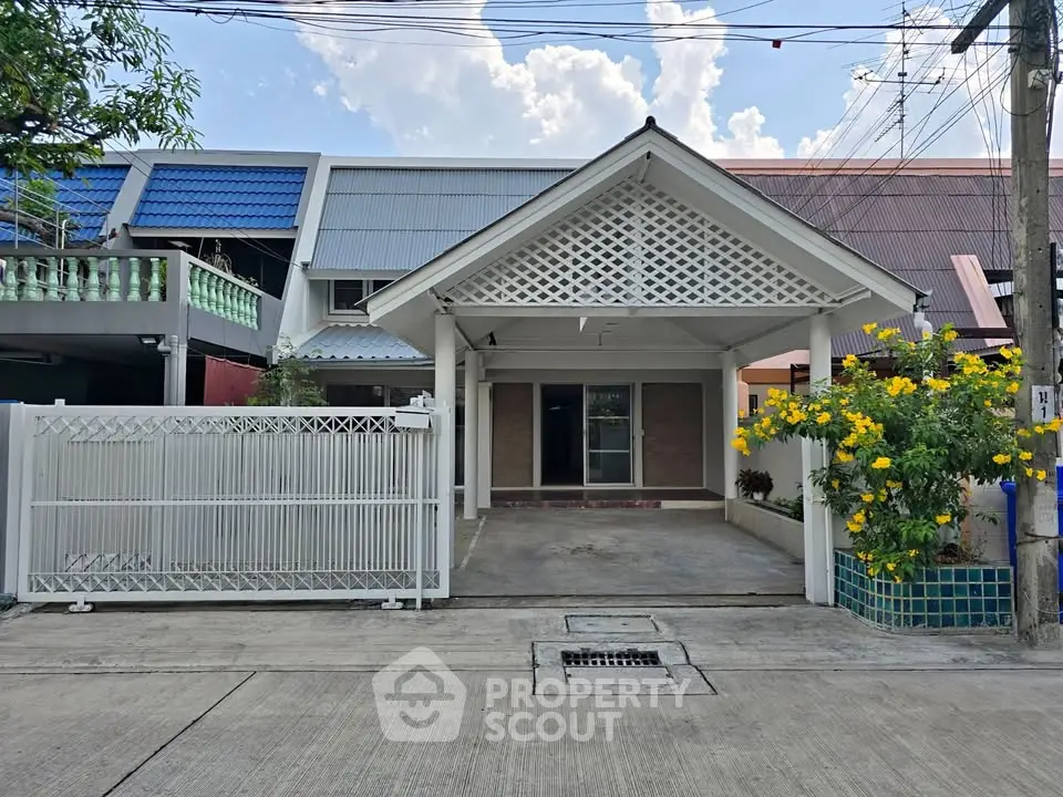 Charming single-story home with gated driveway and vibrant garden in a serene neighborhood.