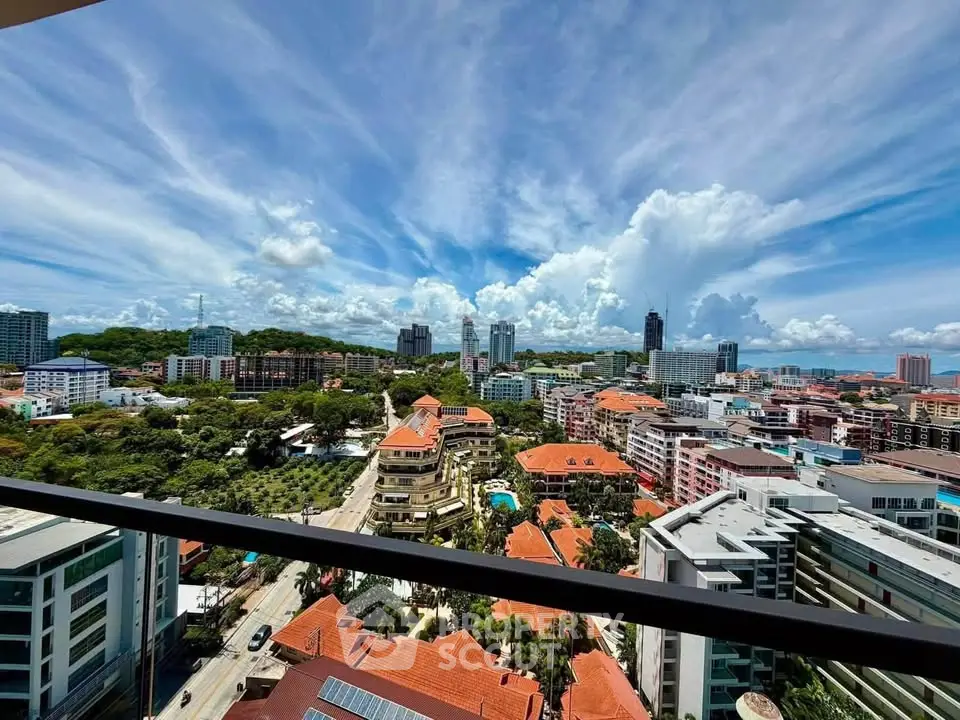 Stunning panoramic cityscape view from a high-rise balcony, showcasing vibrant urban architecture and lush greenery.