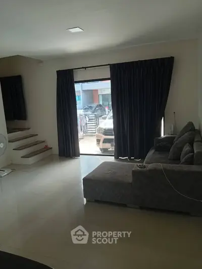 Spacious living room with modern sofa and large window view