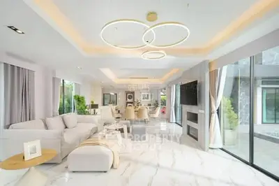 Luxurious open-plan living room with modern decor and large windows offering natural light.