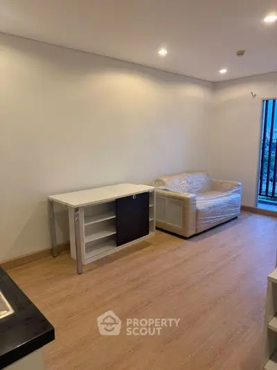 Modern living room with sleek flooring and cozy sofa, perfect for urban living.