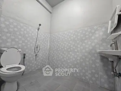 Minimalist bathroom with gray tile design and modern fixtures.