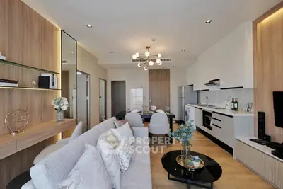 Modern living room with open kitchen, stylish decor, and elegant lighting in a contemporary apartment.