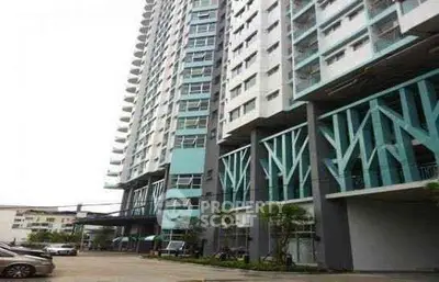 Modern high-rise residential building with unique architectural design and ample parking space.
