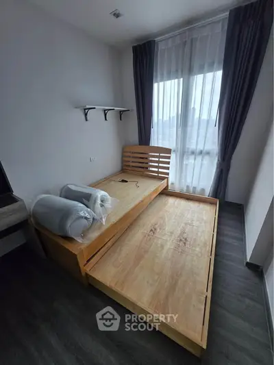 Modern bedroom with wooden bed frame and large window with curtains