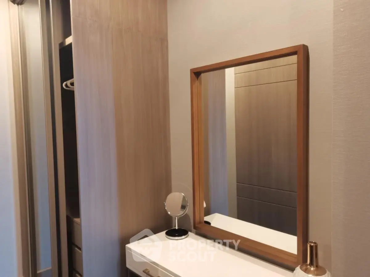 Modern bedroom with stylish wooden mirror and sleek storage solutions.