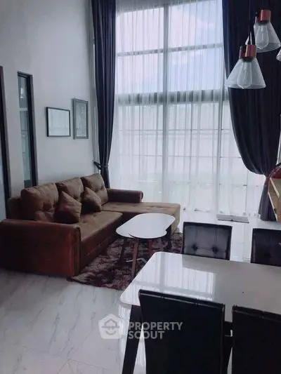 Spacious living room with high ceilings and large windows in modern apartment.