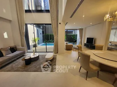 Luxurious open-plan living room with pool view and elegant furnishings