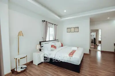 Spacious bedroom with elegant decor and wooden flooring