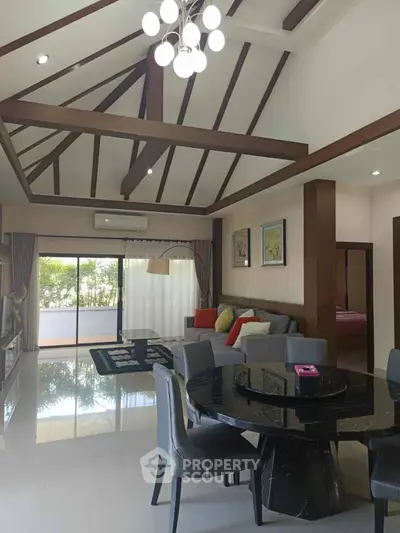 Spacious open-plan living room with modern dining area and high ceilings