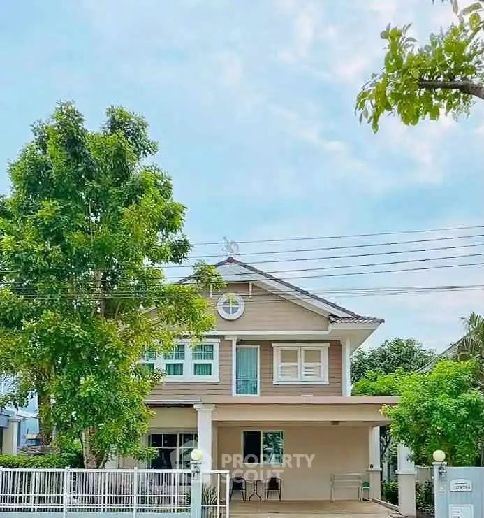 Charming two-story house with lush greenery and spacious driveway