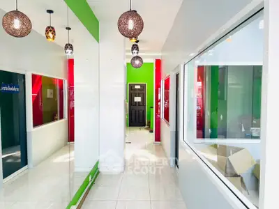 Modern office corridor with vibrant colors and stylish lighting fixtures.