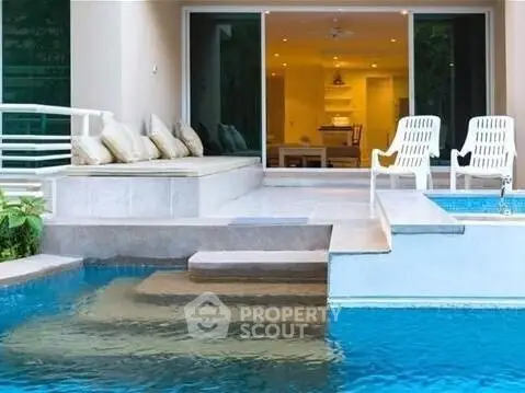 Luxurious poolside view with modern patio and open living area, perfect for relaxation and entertainment.