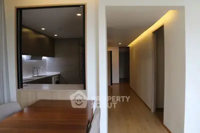 Modern interior with open kitchen and dining area featuring sleek wooden finishes.