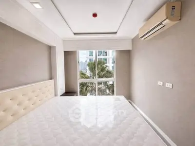 Modern bedroom with large window and air conditioning, offering a serene view of palm trees and cityscape.