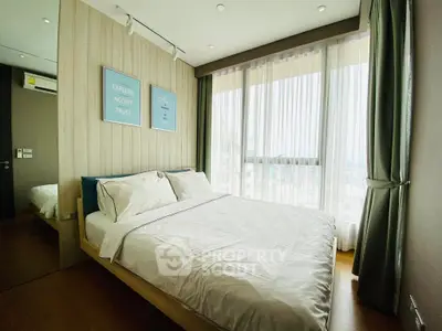 Bright and cozy bedroom with large windows and modern decor in a high-rise apartment.
