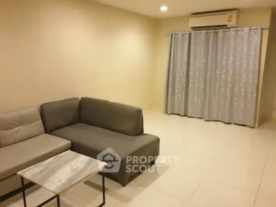 Spacious living room with modern sofa and air conditioning in a cozy apartment.