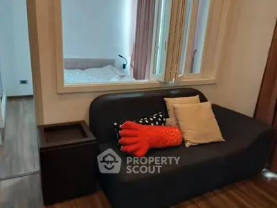 Cozy living room with modern sofa and view into bedroom, perfect for urban living.